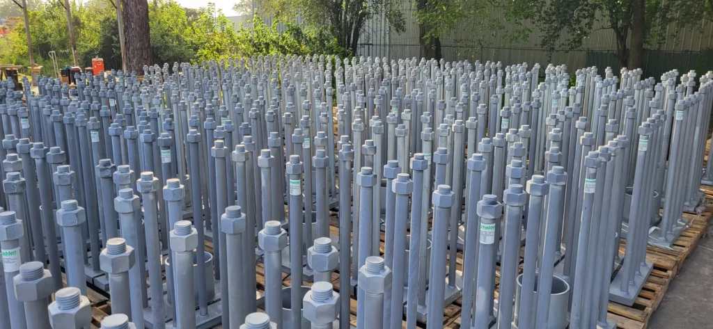 Hundreds of hot-dip galvanized embed assemblies staged upright on pallets in the Madden Bolt yard