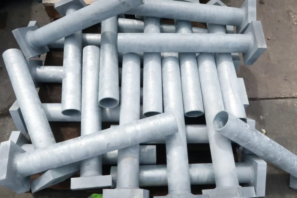 Hot-dip galvanized pipe embeds with welded base plates stacked for shipment