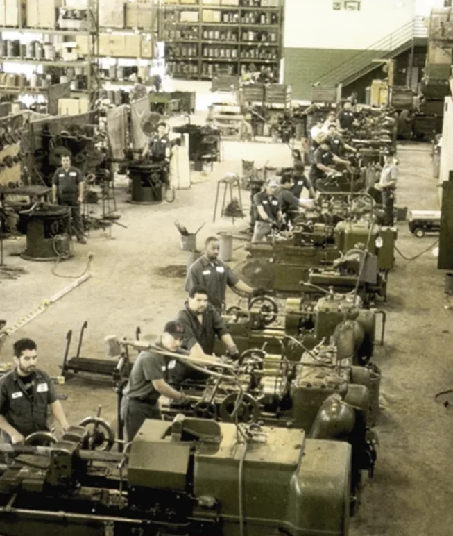 Machinists running rows of bolt-threading machines on the Madden Bolt shop floor in 1988