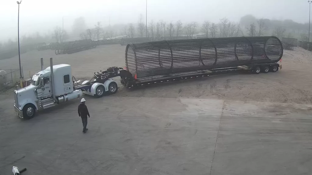 Oversized threaded rebar anchor cage loaded on a lowboy trailer for delivery