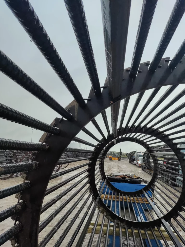 Axial detail of a rebar anchor cage, threaded bars spiraling toward a central steel ring.