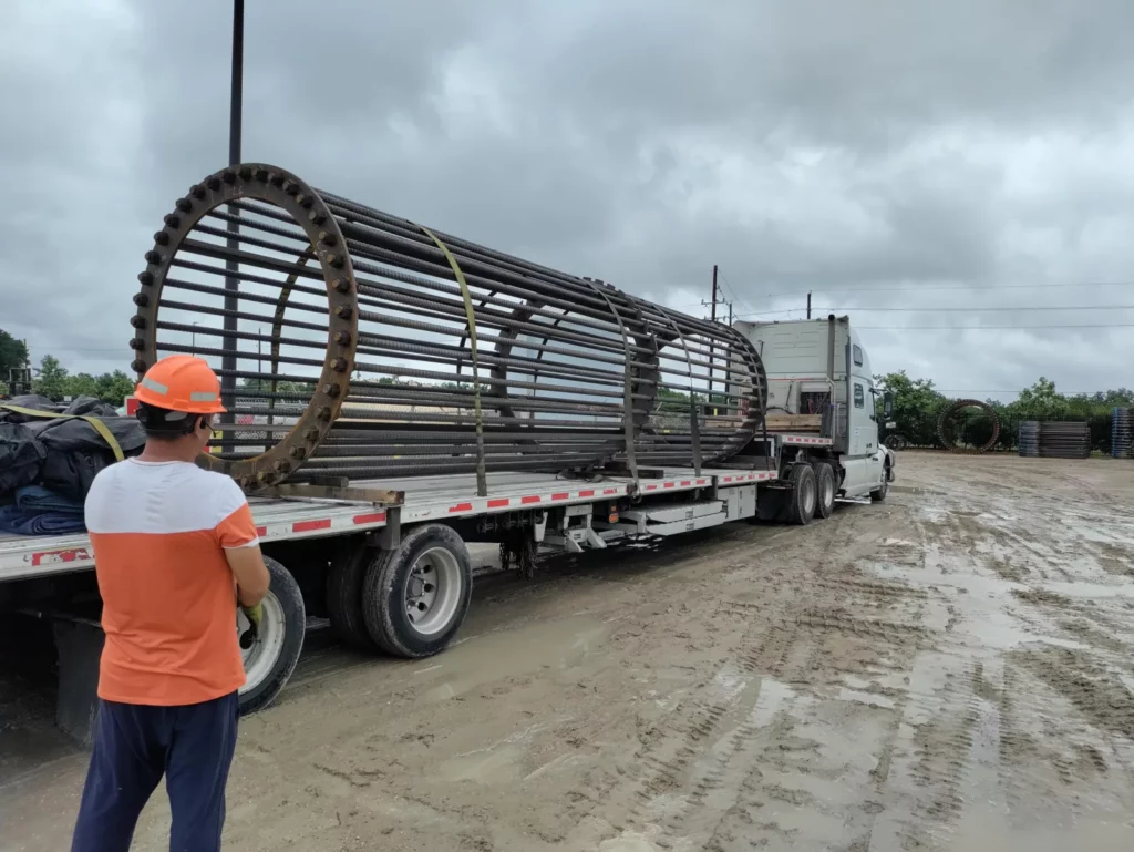 Long rebar anchor cage strapped to a flatbed semi-truck, ready to ship from the Houston yard.